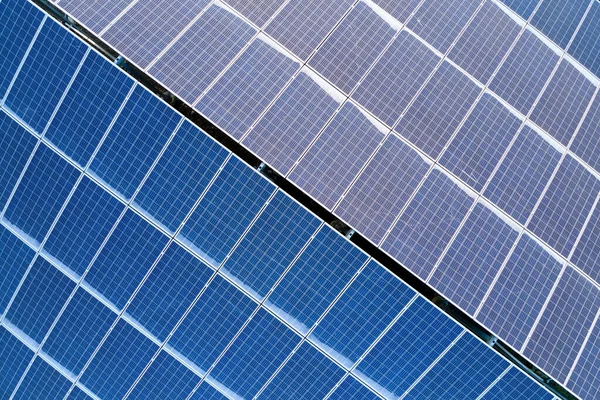 Telhado de construção de vista aérea com fileiras de painéis fotovoltaicos solares azuis para a produção de energia elétrica ecológica limpa. Eletricidade renovável com conceito de emissão zero — Fotografia de Stock