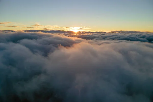 Vista aérea desde arriba a gran altitud de densas nubes de cúmulos hinchados volando por la noche. Increíble puesta de sol desde el punto de vista de la ventana del avión —  Fotos de Stock