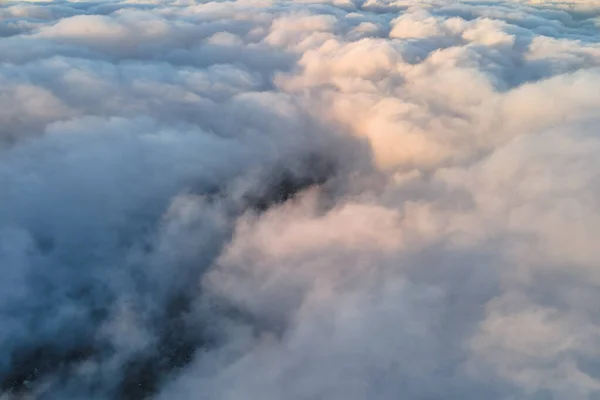 Luftaufnahme aus der Höhe einer entfernten Stadt, die vor dem Regensturm am Abend mit geschwollenen Kumuluswolken bedeckt ist. Blick aus dem Flugzeug auf bewölkte Landschaft — Stockfoto