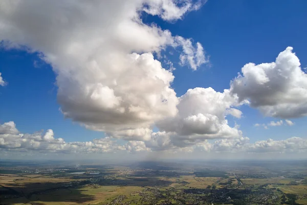 Letecký pohled z velké nadmořské výšky země pokrytý bílými nafouklými kumulativními mraky za slunečného dne — Stock fotografie