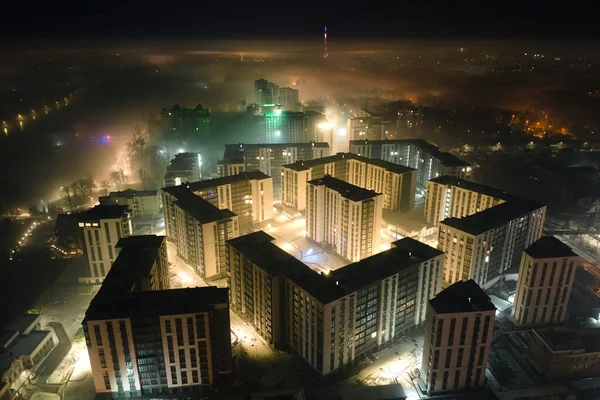 Widok z lotu ptaka wysokie budynki mieszkalne i jasne oświetlone ulice w mieście Iwano-Frankowsk, Ukraina dzielnicy mieszkalnej w nocy. Ciemny krajobraz miejski — Zdjęcie stockowe