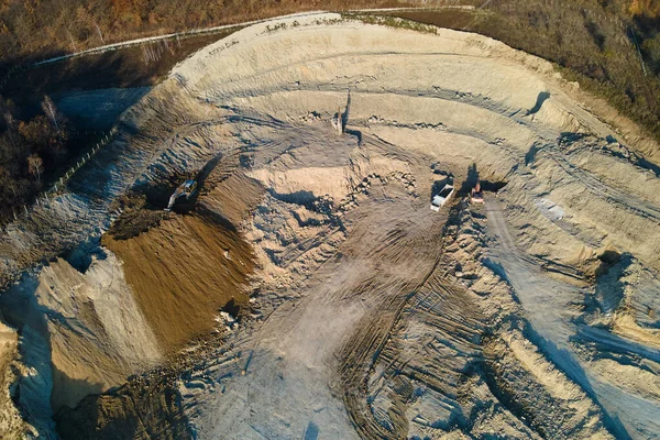 Vista aérea da mina a céu aberto de materiais de arenito para a indústria da construção com escavadoras e caminhões basculantes. Equipamento pesado na mineração e produção de conceito de minerais úteis — Fotografia de Stock