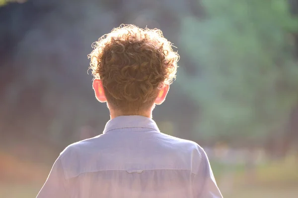 Vista posterior de un joven adolescente con el pelo rubio rizado — Foto de Stock