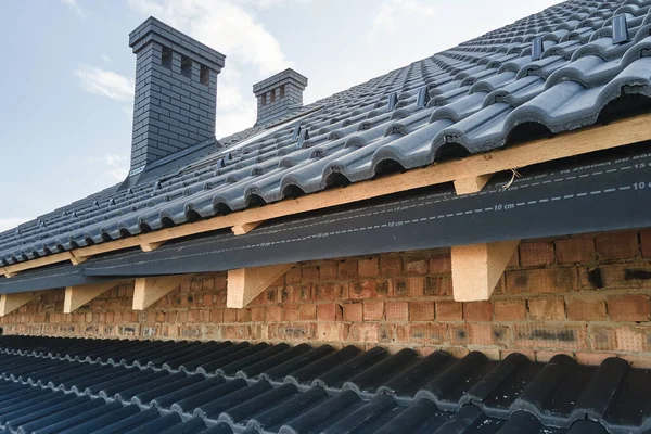 Detailní záběr střechy domu pokryté keramickými šindely. Dlažba krytiny budovy ve výstavbě — Stock fotografie