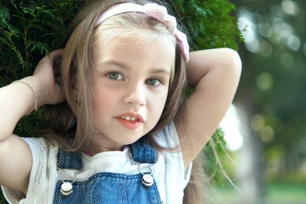 Porträtt av glad söt barn flicka stående i sommarparken tittar i kameran — Stockfoto