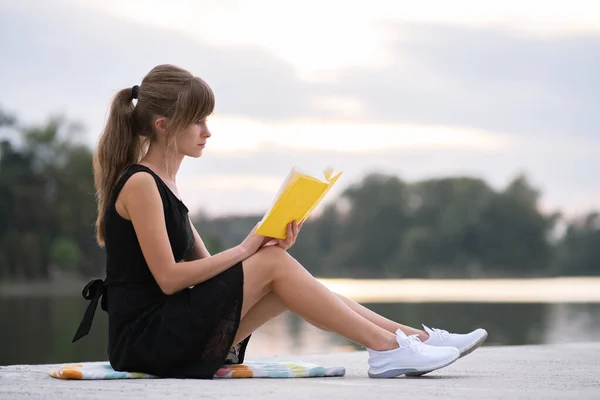 Mujer joven descansando en el parque de verano leyendo un libro. Educación y concepto sudy —  Fotos de Stock