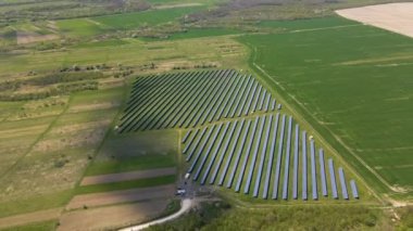 Temiz ekolojik elektrik enerjisi üretmek için birçok sıra güneş fotovoltaik paneli bulunan sürdürülebilir büyük elektrik santralinin havadan görünüşü. Sıfır emisyon kavramı ile yenilenebilir elektrik