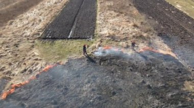 İtfaiyecilerin kurak mevsimde yanan çayır tarlasını havadan görünüşü. Doğal afet ve iklim değişikliği kavramı