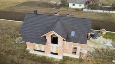 Seramik kiremitlerle kaplı evin çatısının havadan görünüşü. İnşaat halindeki binanın döşemeleri