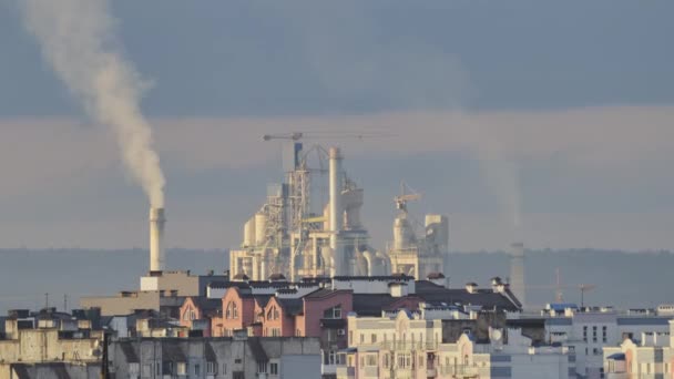 Zeitraffer eines Zementwerks mit hoher Fabrikstruktur und Turmdrehkränen im Industriegebiet in der Nähe des Stadtgebiets. Fertigung und globales Branchenkonzept — Stockvideo