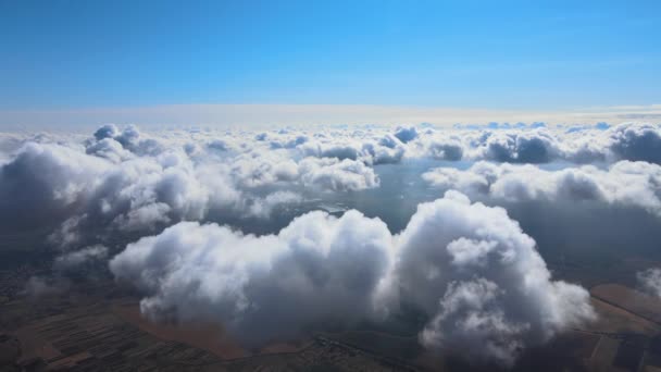 Vista aérea desde la ventana del avión a gran altitud de la tierra cubierta de nubes de cúmulos hinchados que se forman antes de la tormenta — Vídeo de stock