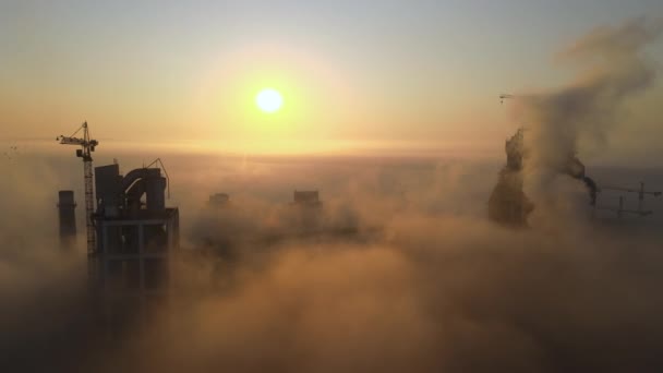 Vista aérea de la fábrica de cemento con estructura de planta de hormigón alto y grúa torre en el sitio de fabricación industrial en la noche brumosa. Producción y concepto de industria global — Vídeos de Stock