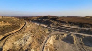 Kazı araçları ve çöp kamyonlarıyla inşaat endüstrisi için kireçtaşı malzemelerinin açık maden sahasının hava görüntüsü