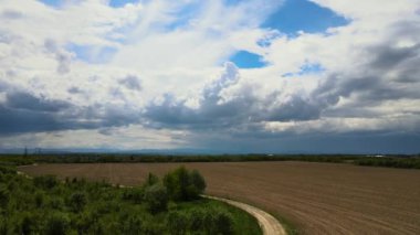 Fırtınalı bir fırtınada tarlalar üzerinde oluşan kara bulutların manzarası.