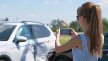 Stresli kadın sürücü, trafik kazası üstüne trafik kazası sonrası cep telefonu kamerasıyla fotoğraf çekiyor. Yol güvenliği ve sigorta kavramı