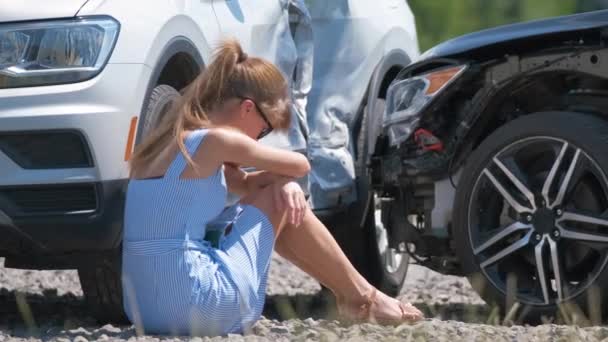 Conductora estresada sentada en el lado de la calle sorprendida después de un accidente de coche. Concepto de seguridad vial y seguros — Vídeo de stock