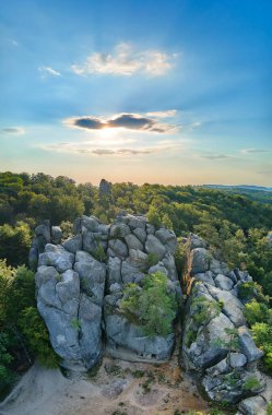 Yeşil orman ağaçları ve sık ağaçlar arasında büyük kayalık kayaların olduğu parlak manzaranın havadan görünüşü. Vahşi ormanın güzel manzarası