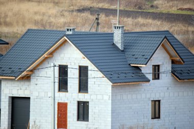 Seramik kiremitlerle kaplı evin çatısının havadan görünüşü. İnşaat halindeki binanın döşemeleri