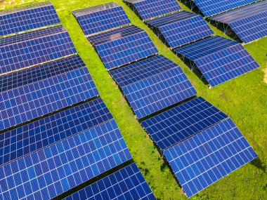 Temiz ekolojik elektrik enerjisi üretmek için sıra sıra güneş fotovoltaik panelleri olan sürdürülebilir büyük elektrik santralinin havadan görünüşü. Sıfır emisyon kavramı ile yenilenebilir elektrik