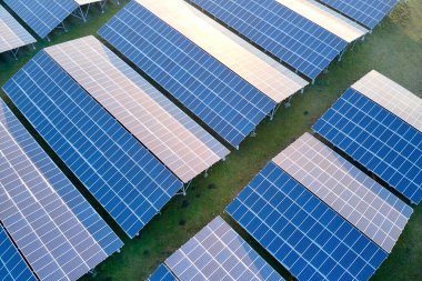 Temiz ekolojik elektrik enerjisi üretmek için sıra sıra güneş fotovoltaik panelleri olan sürdürülebilir büyük elektrik santralinin havadan görünüşü. Sıfır emisyon kavramı ile yenilenebilir elektrik.