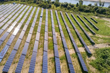 Yeşil alandaki güneş enerjisi santralinin havadan görüntüsü. Temiz ekolojik enerji üretmek için panelleri olan elektrik çiftliği