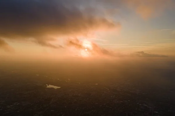 Luchtfoto van grote hoogte van verre stad bedekt met gezwollen cumulus wolken vormen voor regenbui in de avond. Vliegtuigstandpunt van bewolkt landschap — Stockfoto