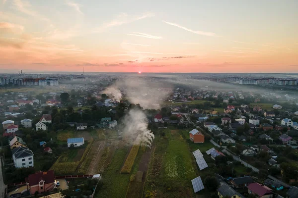 Vista aérea de las hogueras de residuos agrícolas de pasto seco y rastrojo de paja ardiendo con humo espeso que contamina el aire durante la estación seca en las tierras de cultivo causando calentamiento global y humos carcinógenos — Foto de Stock