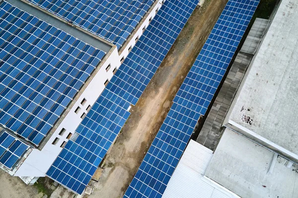 Αεροφωτογραφία μπλε φωτοβολταϊκών ηλιακών συλλεκτών τοποθετημένων σε στέγη βιομηχανικού κτιρίου για την παραγωγή πράσινης οικολογικής ηλεκτρικής ενέργειας. Παραγωγή έννοιας της βιώσιμης ενέργειας — Φωτογραφία Αρχείου