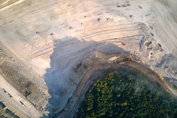 Вид с воздуха на карьер добычи известняковых материалов для строительной промышленности с экскаваторами и самосвалами — стоковое фото
