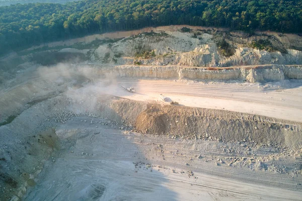 Вид с воздуха на открытую шахту добычи известняковых материалов для строительной промышленности с экскаваторами и самосвалами — стоковое фото