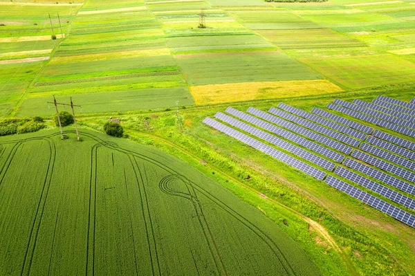Letecký pohled na solární elektrárnu na zeleném poli. Elektrické panely pro výrobu čisté ekologické energie — Stock fotografie