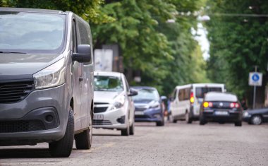Sokak kenarında park halindeki arabalarla şehir trafiği