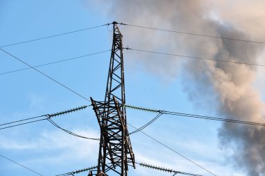 Kömür santraline karşı yüksek voltajlı elektrik direkleri siyah dumanlı yüksek borular atmosferi kirletiyor. Fosil yakıt kavramına sahip elektrik enerjisi üretimi