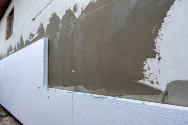 Termal koruma için ev cephesi duvarına köpük yalıtım çarşafları kurulumu