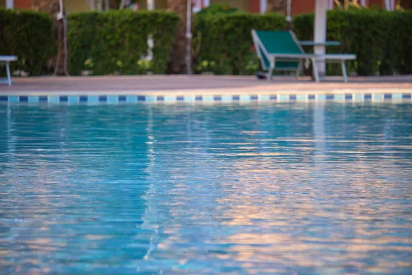 Agua azul clara con pequeñas olas onduladas en la piscina del complejo tropical. Concepto vacaciones de verano —  Fotos de Stock