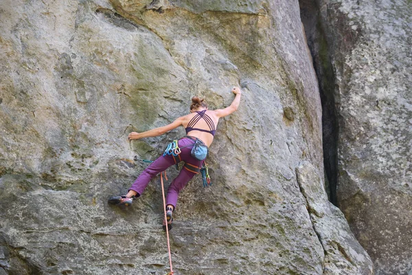 岩の多い山の急な壁を登る少女登山を決定した。難しいルートを克服するスポーツ女性。極端なスポーツやロッククライミングの趣味の概念に従事 — ストック写真