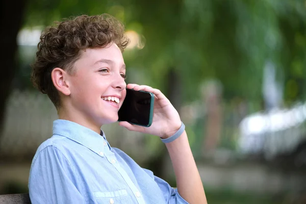 Niño feliz hablando por celular al aire libre en el parque de verano — Foto de Stock