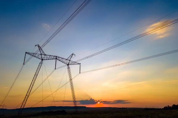 Torri ad alta tensione con linee elettriche al tramonto — Foto Stock