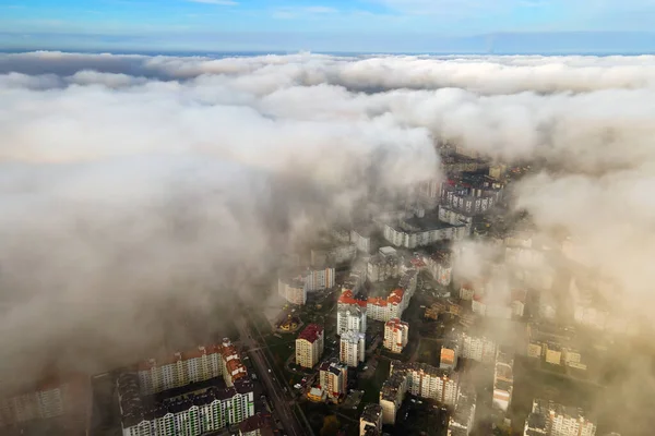 高層ビルが立ち並ぶ近代都市の上からのふわふわした白い雲の空中写真 — ストック写真