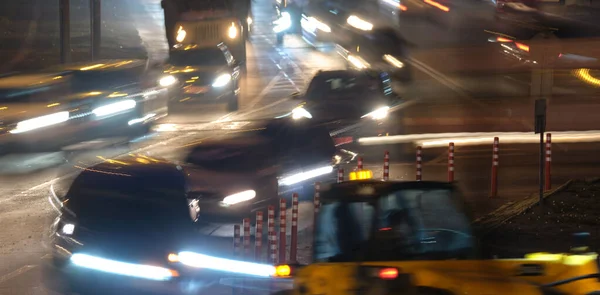 Пробки на дорогах со многими машинами, медленно движущимися по городской улице ночью. Концепция городского транспорта — стоковое фото