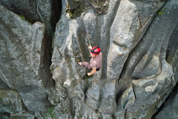 Déterminé grimpeur escalade mur escarpé de montagne rocheuse. Sportif surmonter la route difficile. S'engager dans des sports extrêmes et le concept de passe-temps d'escalade — Photo