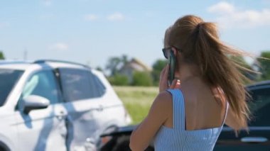 Stresli kadın sürücü cadde kenarında cep telefonuyla konuşuyor. Araba kazasından sonra acil servisi arıyor. Yol güvenliği ve sigorta kavramı