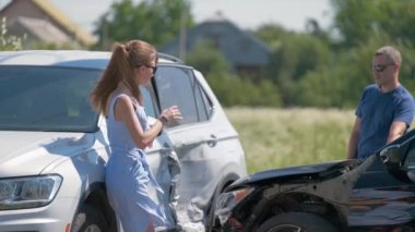 Öfkeli kadın ve ağır hasarlı araçların erkek sürücüleri trafik kazasında kimin suçlu olduğunu savunuyorlar. Yol güvenliği ve sigorta kavramı