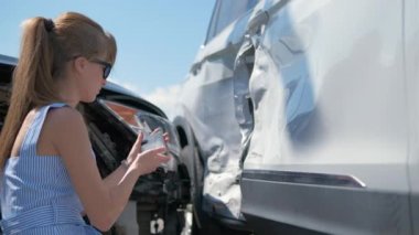 Stresli kadın sürücü, trafik kazası üstüne trafik kazası sonrası cep telefonu kamerasıyla fotoğraf çekiyor. Yol güvenliği ve sigorta kavramı