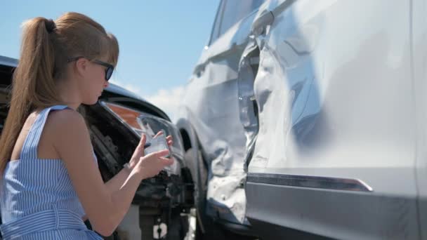 Stressed woman driver taking photo on mobile phone camera after vehicle collision on street side for emergency service after car accident. Road safety and insurance concept — Video Stock