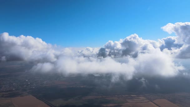 Vista aérea desde la ventana del avión a gran altitud de la tierra cubierta con nubes de cúmulos hinchados blancos — Vídeos de Stock