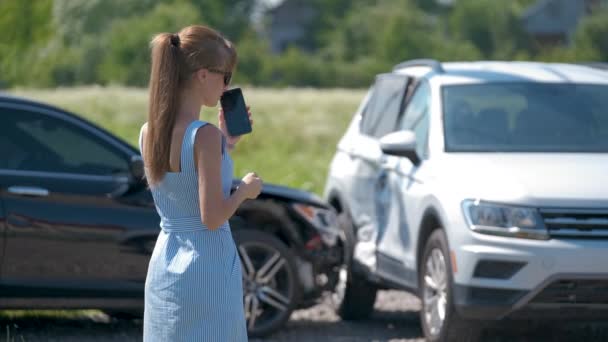 Αγχωμένη οδηγός μιλάει στο τηλέφωνο στην άκρη του δρόμου κοντά στο τρακαρισμένο όχημά της καλώντας για βοήθεια έκτακτης ανάγκης μετά από αυτοκινητιστικό ατύχημα. Έννοια οδικής ασφάλειας και ασφάλισης — Αρχείο Βίντεο