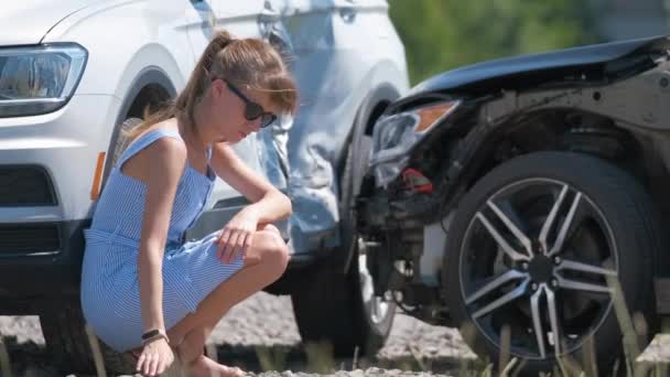 Conductora triste sentada en el lado de la calle sorprendida después de un accidente de coche. Concepto de seguridad vial y seguro de vehículos — Vídeos de Stock