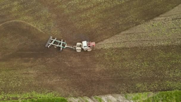Aerial view of tractor plowing agriculural farm field preparing soil for seeding in summer — Vídeo de Stock