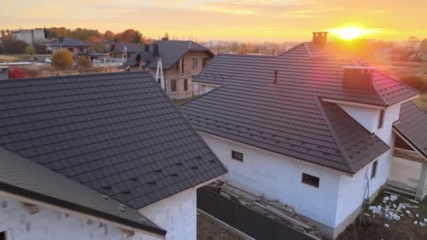 Vista aérea de casa inacabada con paredes de hormigón ligero aireado y marco de techo de madera cubierto con azulejos metálicos en construcción — Vídeos de Stock